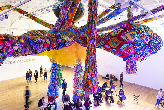 People gather and sketch under Joana Vasconcelos' huge sculptural installation.