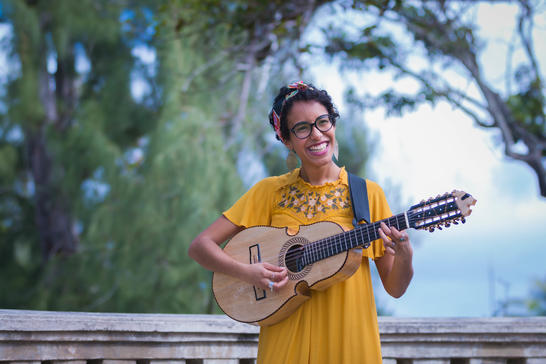 Fabiola Mendez smiling playing the cuatro