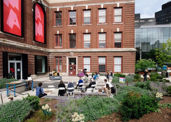 Visitors sketching in MAAM's outdoor plaza.