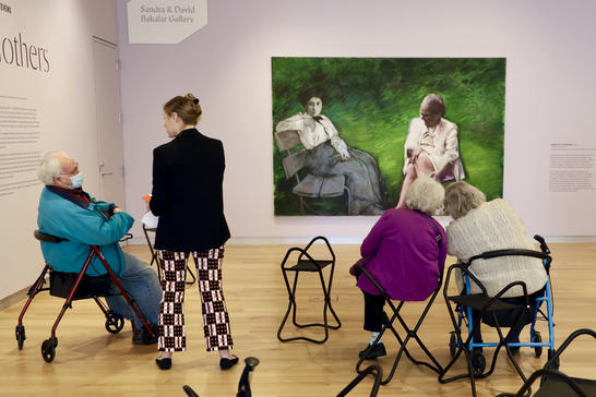 A group of visitors seated in the gallery led by a MAAM educator
