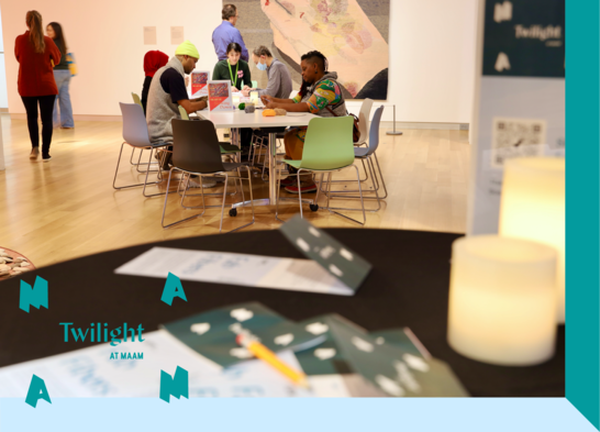 A group of people sitting at a table with art supplies.