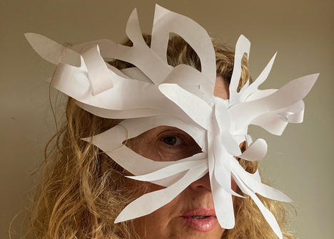 A person wearing a white mask made out of plain paper.