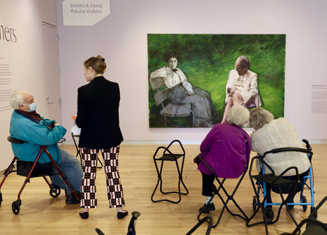 A group of visitors seated in the gallery led by a MAAM educator