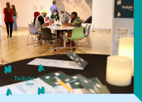 A group of people sitting at a table with art supplies.