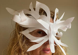 A person wearing a white mask made out of plain paper.