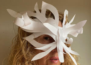 A person wearing a white mask made out of plain paper. 