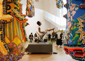 Performer and live drawing model seated amongst Joana Vasconcelos sculpture