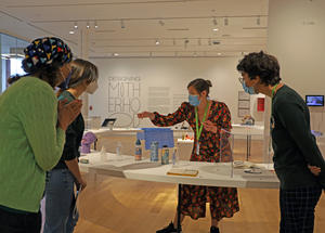 A small group taking an interactive tour of the Designing Motherhood exhibition.