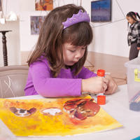 Young girl make a yellow collage using a glue stick