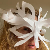 A person wearing a white mask made out of plain paper. 