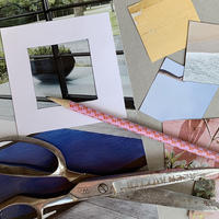 A mix of materials used in the activity, including scissors, a pencil, found photos, and a cut out paper square.