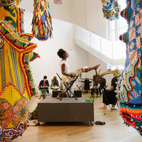 Performer and live drawing model seated amongst Joana Vasconcelos sculpture