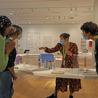 A small group taking an interactive tour of the Designing Motherhood exhibition.
