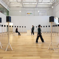 Visitors experience Jace Clayton's installation of 40 speakers on plain wooden stands