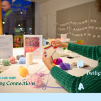 Twilight at MAAM: image of two visitors in the Big Ideas studio, one person is seated holding a small cardboard loom