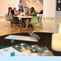 A group of people sitting at a table with art supplies.