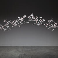 60 porcelain hatchets, white with floral pattern, suspended in an arc on a dark background