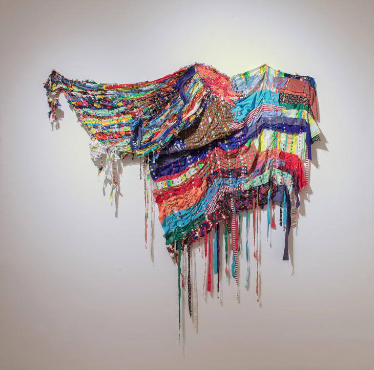 Brightly colored fabric wall sculpture made out of recycled fabrics