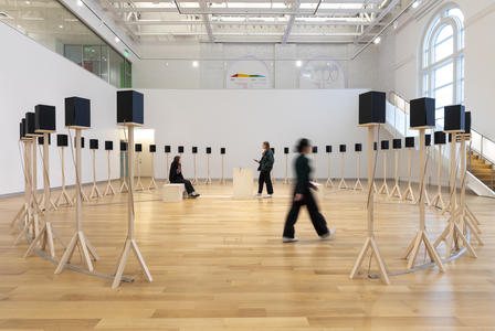 Visitors experience Jace Clayton's installation of 40 speakers on plain wooden stands