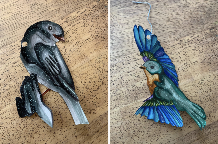 Two cut out paintings of multicolored birds