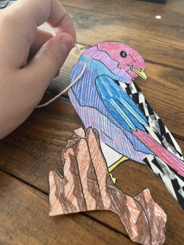 Photograph of someone putting a hole in their bird artwork