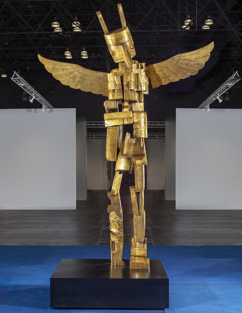 Large bronze totem pole in multiple pieces with an eagle's head and outstretched wings